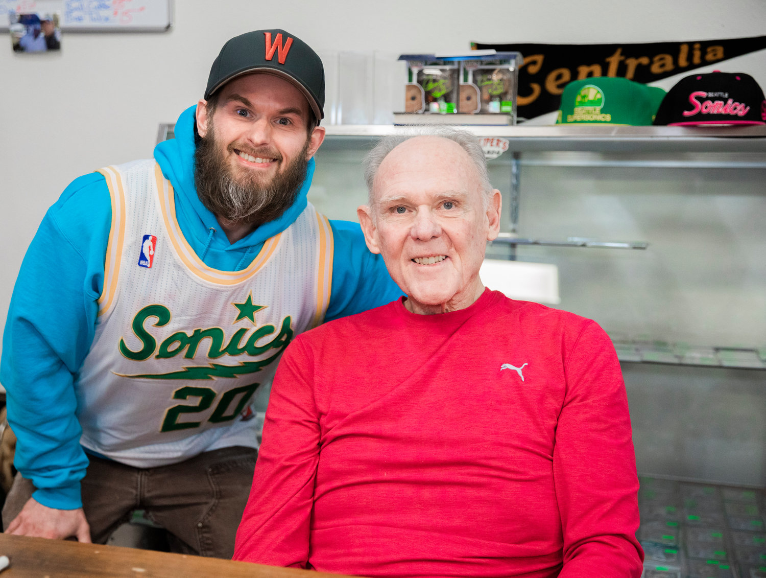 Dan Keiper, owner of Keiper’s Cards, smiles for a photo with former professional basketball player and coach George Karl on Friday in downtown Centralia.